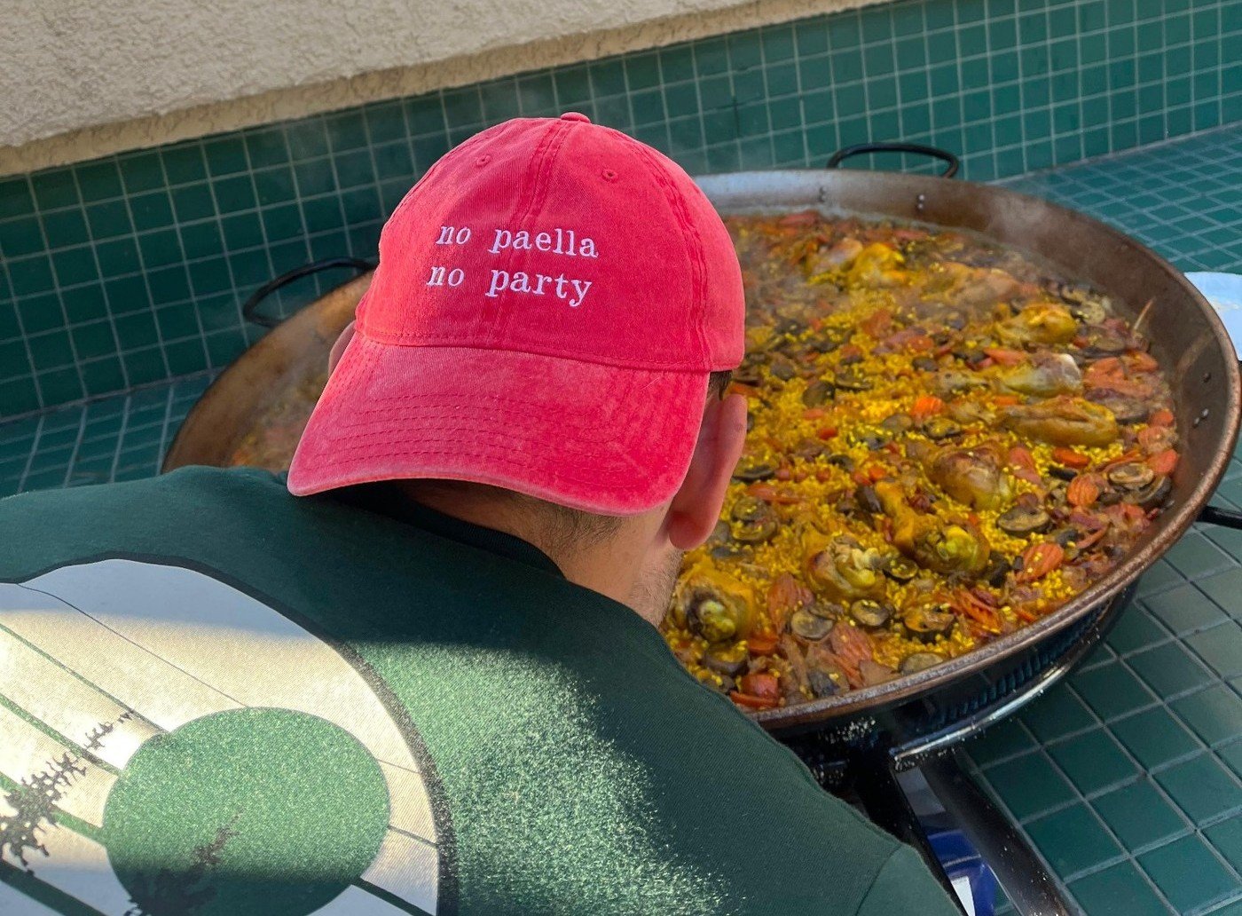 Pau cooking paella wearing a red cap