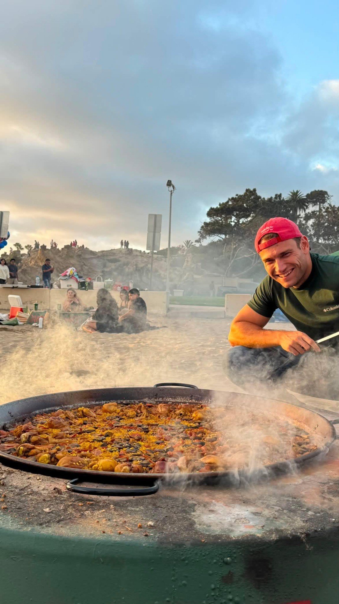 Pau cooking a large paella at the beach